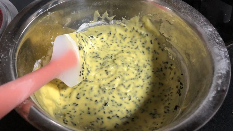 无麸质芝麻米粉戚风,取三分之一蛋白，加入蛋黄糊中，用刮刀拌匀。