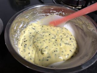 无麸质芝麻米粉戚风,全部蛋黄糊倒入蛋白盆中，用刮刀拌匀。注意用翻拌的手法，减少消泡。