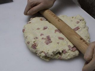 咸香火腿奶酪司康,把面团擀开，折叠几下，折叠时案板和面团表面撒薄粉，这一步不要省略，司康口感酥松的关键。