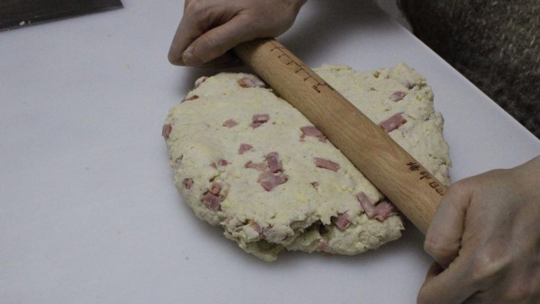 咸香火腿奶酪司康,把面团擀开，折叠几下，折叠时案板和面团表面撒薄粉，这一步不要省略，司康口感酥松的关键。