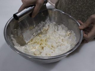 咸香火腿奶酪司康,和面粉一边混合，一边用刮刀切小块拌匀。切的越小越碎越好。