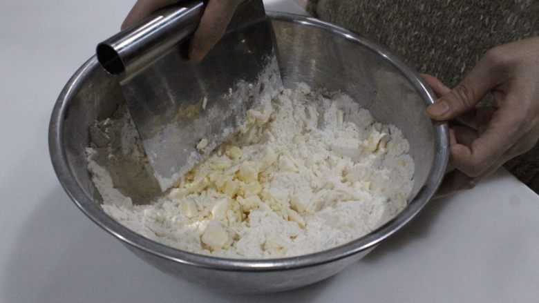 咸香火腿奶酪司康,和面粉一边混合，一边用刮刀切小块拌匀。切的越小越碎越好。