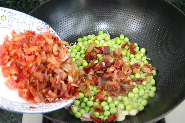 糯米酿猪大肠,倒入豌豆煸炒至表皮起皱，再倒入腊味继续翻炒5分钟左右