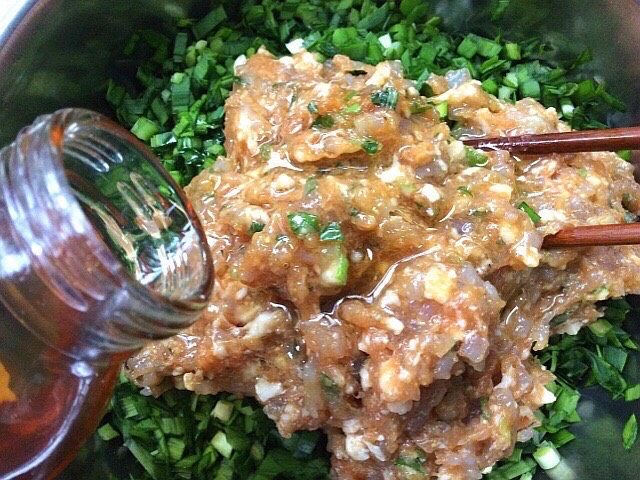 韭菜虾肉锅贴,韭菜切碎把拌好的虾肉放入，倒入熟油搅拌均匀