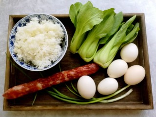腊肠黄金炒饭,准备好米饭，腊肠，鸡蛋，小油菜和香葱。