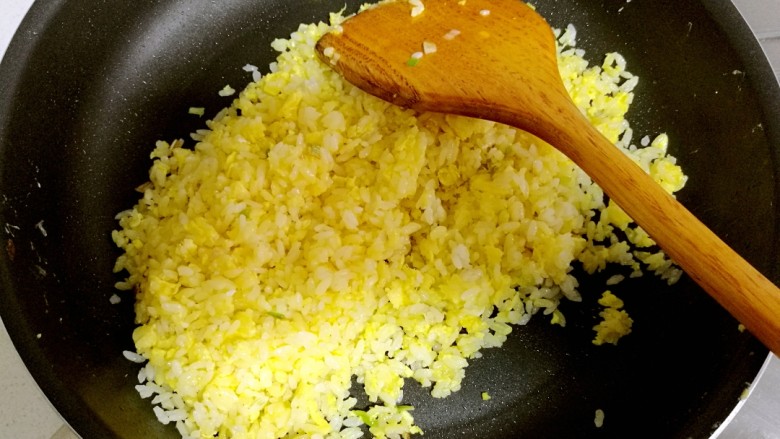 腊肠黄金炒饭,开中火，快速把米饭和蛋液炒匀，使每一粒米饭都裹匀鸡蛋液。