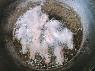 一虾两吃,将裹好淀粉的虾头倒入锅中，炸至变色