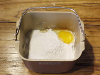 原味基础吐司（面包机版）,然后倒入面粉，将食盐、细砂糖和一个全蛋分别放在面包机的四角。