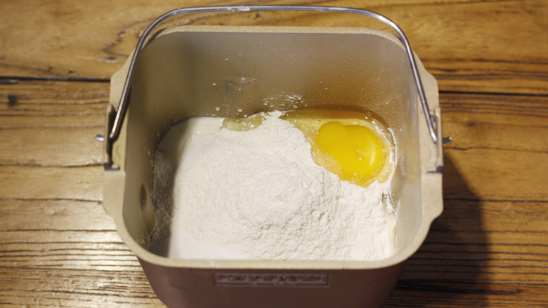 原味基础吐司（面包机版）,然后倒入面粉，将食盐、细砂糖和一个全蛋分别放在面包机的四角。