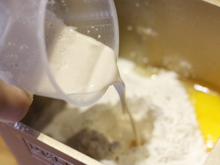 原味基础吐司（面包机版）,在面粉中挖一个面坑，将酵母粉倒入。准备就绪后放入面包机，开启和面模式。