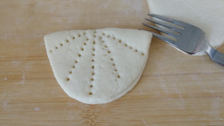 家庭版&荷叶肉夹馍,把粘上面的一面折叠过来（如图）用餐具叉子压成荷叶形（如图）