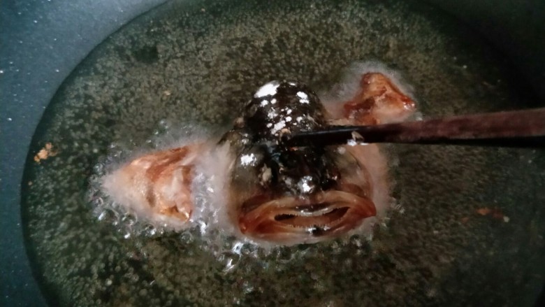 松鼠鲈鱼,放入油锅中，可以借助筷子压住鱼头，定型。炸至微黄捞出。