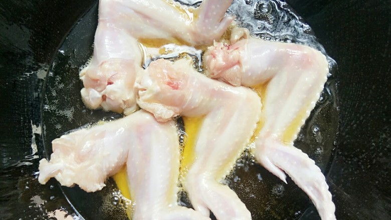 芝麻香沙茶酱鸡翅,锅里放油，油热后放入鸡翅煎