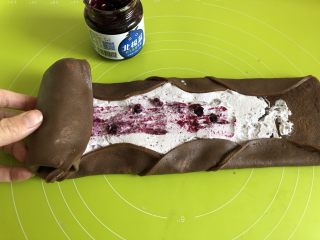 蓝莓可可毛巾卷,把饼皮上下两边向中间折叠，从一头开始卷起