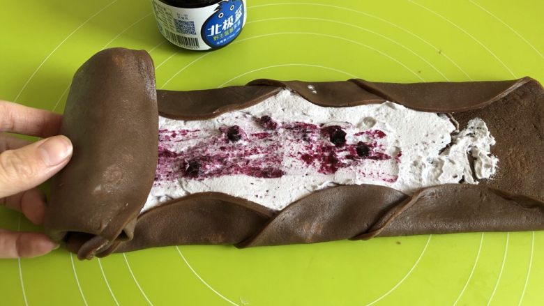 蓝莓可可毛巾卷,把饼皮上下两边向中间折叠，从一头开始卷起