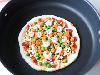 平底锅披萨,胡萝卜、豌豆、虾仁依次放上去；盖盖子焖10分钟左右；