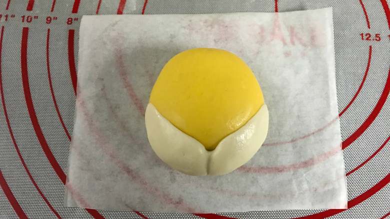 柴犬豆沙包,把包入豆沙馅的面团稍整成上面小下面大的形状后把白色面片贴在黄色面团的下半部。