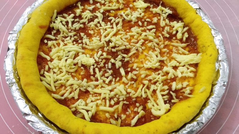 南瓜虾仁培根披萨,取出抹批萨酱，薄薄的撒一层奶酪