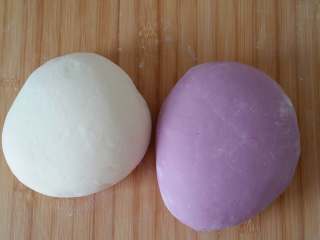紫薯素包子,面板上撒少量干面粉，将两种面团反复揉搓排气到位，期间可以分次加少量干面粉，尤其是紫色面团，要揉到不粘手为止。揉好的紫色面团约732克，白色面团约637克左右。