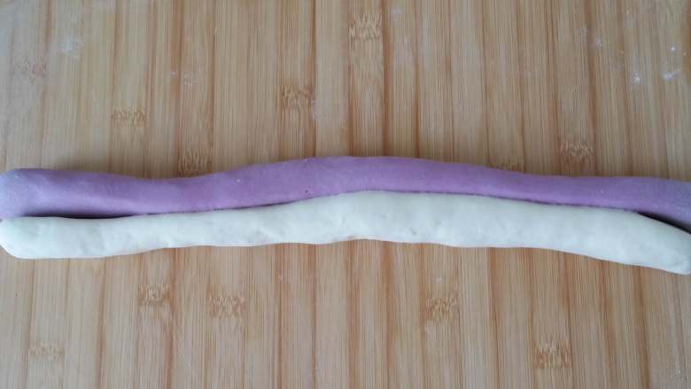 紫薯素包子,将两种面团轻轻搓在一起，让两种面的贴合面粘合在一起。
