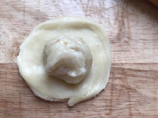 糯米酥皮老婆饼,拿起第一个酥皮按扁轻轻擀成圆形，放一个内陷在里面。