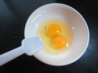 美味蛋炒饭,鸡蛋磕入碗里，放一丢丢盐。