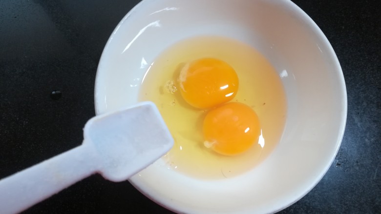 美味蛋炒饭,鸡蛋磕入碗里，放一丢丢盐。