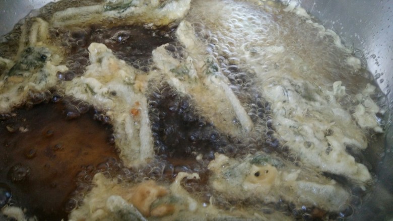 炸香椿鱼,这时候就把香椿挂糊一个一条一条的放进油锅里炸