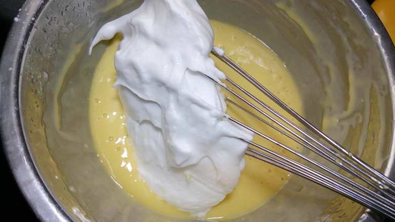 橙味戚风,用手抽或刮刀取1/3的蛋白霜放入蛋黄糊碗中。