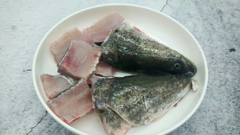 高汤撒椒酸菜鱼,鱼头对半切开，鱼骨头切寸断