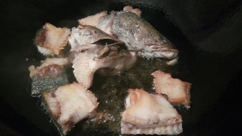 高汤撒椒酸菜鱼,锅中加油烧至7成热，倒入鱼骨，煎至两面金黄