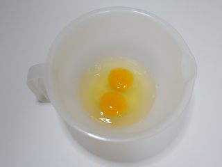 儿童食谱—鸡刨豆腐,鸡蛋打入碗中。
