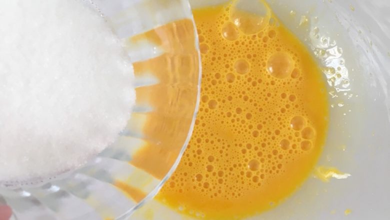 蛋黄小饼干,用打蛋器将鸡蛋打散，加入三分之一的糖