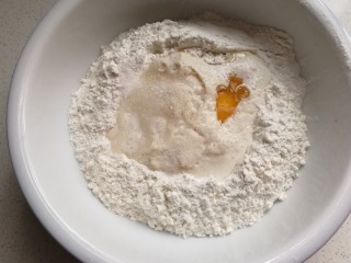 奥利奥面包卷,面粉中间挖洞，依次倒入牛奶酵母液、鸡蛋、盐、10克白糖和20克牛奶