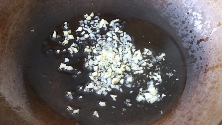 土豆豆角焖饭,锅内放适量的色拉油，放入大蒜末炒香；