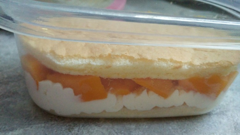 芒果蛋糕盒子,芒果铺在淡奶油上顶部再放一片蛋糕片