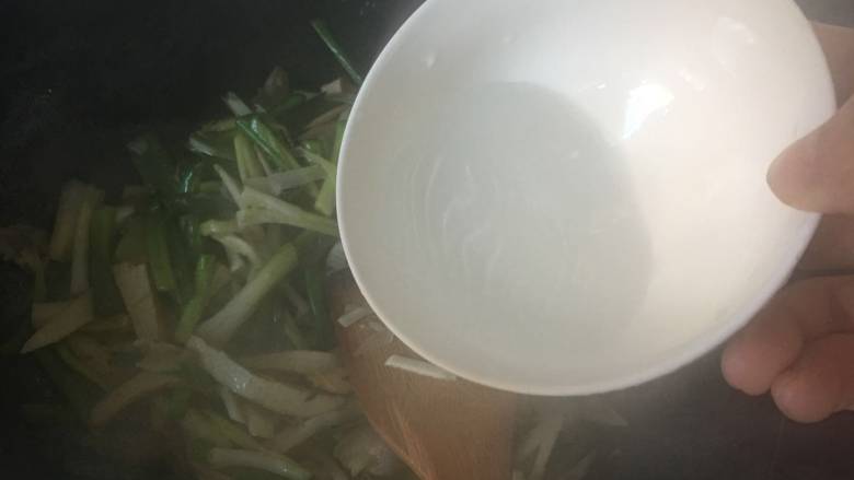 咸肉香干炒青蒜,可以加入一点水，继续翻炒；不需要盖锅盖，保持蒜叶的色泽；