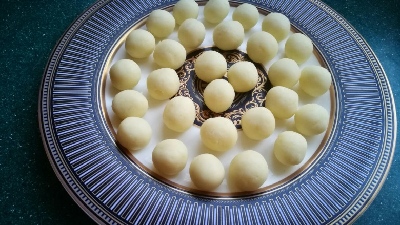 椒盐小土豆球,将土豆泥搓成大小均匀的小圆球，摆在盘子里。这么整齐的摆在盘子里可不光是为了好看的，是为下一步快速方便的裹粉的。
