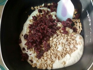 蔓越莓牛轧糖,翻拌均匀后倒入花生米和蔓越莓，快速翻拌！