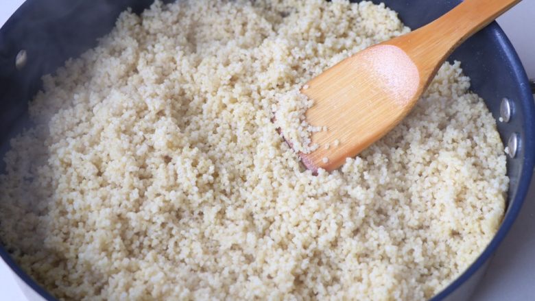 小葱炒小米,锅内放稍微多的小米，倒入小米翻炒；