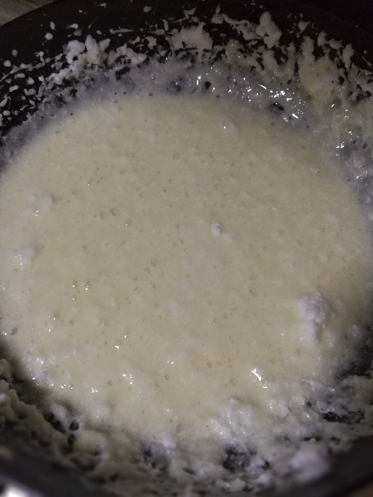牛扎雪花酥,蛋白与麦芽糖拌匀后倒入已融化的75g黄油，用木铲尽量搅拌均匀。不要再用打蛋器搅拌，黄油会飞溅出锅的！！切记切记！