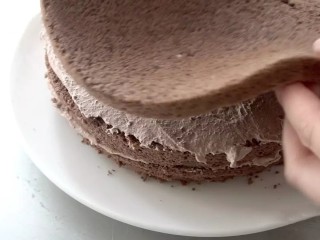 滴落巧克力蛋糕,放上第二层、第三层蛋糕胚，用同样的方法涂抹奶油