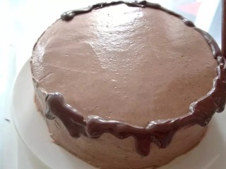 滴落巧克力蛋糕,用裱花袋在蛋糕周围挤出滴落的状态