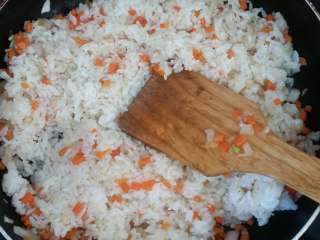 虾仁炒饭,用铲子边压边炒，将米饭炒散。