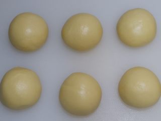 椰蓉花朵面包,分成六等份，滚圆，保鲜膜室温醒发15分钟。