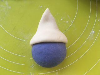 可爱的蓝精灵,内侧抹点水，包裹在蓝色顶部，对捏好收口，捏成三角形，就成了蓝精灵的帽子