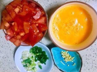 番茄鸡蛋竹升面,鸡蛋打入碗，加半勺盐调均匀，番茄用食盐浸泡洗净切一指见宽的丁，小葱切葱花，老姜