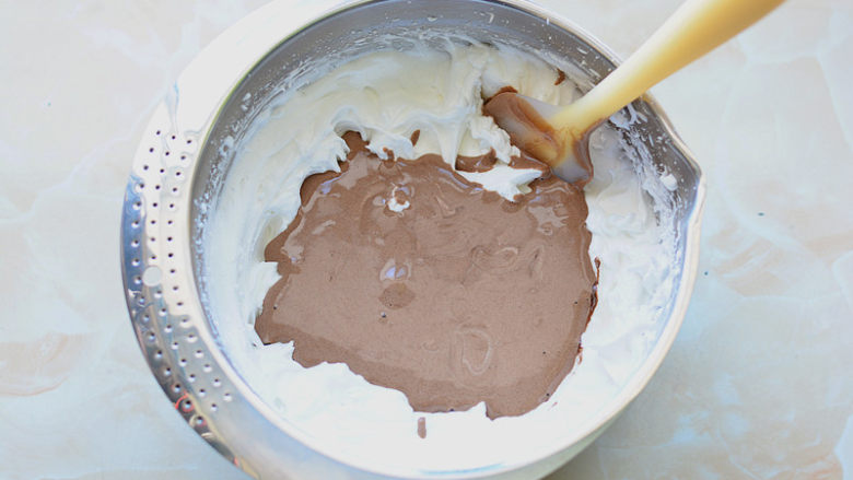 脏脏蛋糕,然后将混合好的可可面糊全部倒入剩余的蛋白霜里，刮刀画Z字形快速翻拌均匀。拌好的面糊细腻有光泽。
