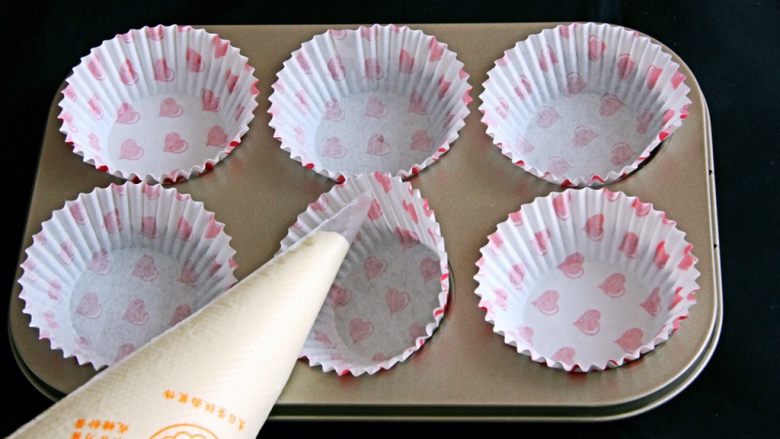 纸托小蛋糕,蛋糕糊装入大号的裱花袋中，模具中放入纸托。