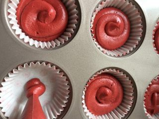 红丝绒系列纸杯蛋糕,取一半面糊装入裱花袋，挤入模具内，六分满即可